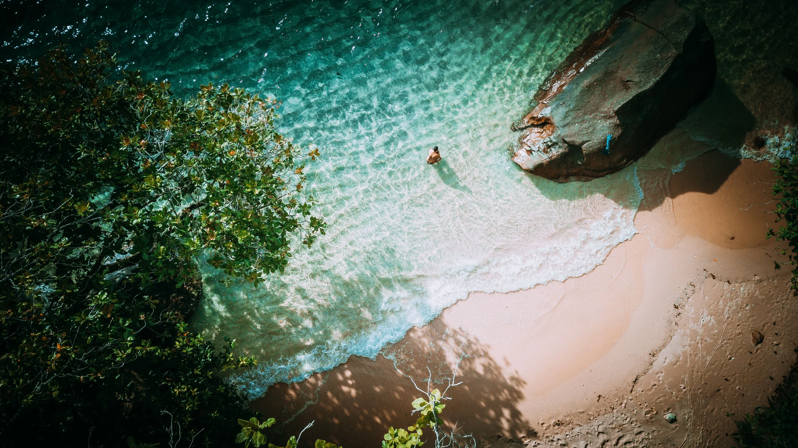 Clear water and granite beside a beach on Mahé